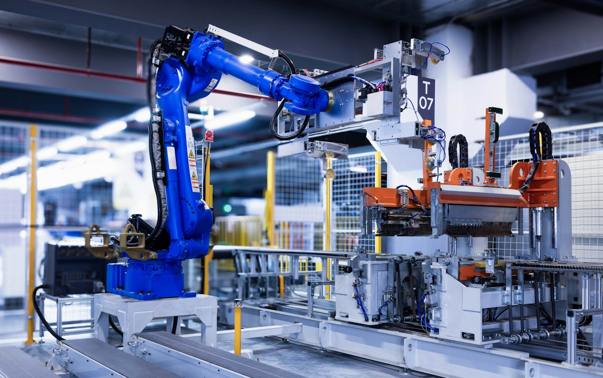 Herramienta de un robot industrial que transporta una pieza en la fábrica.