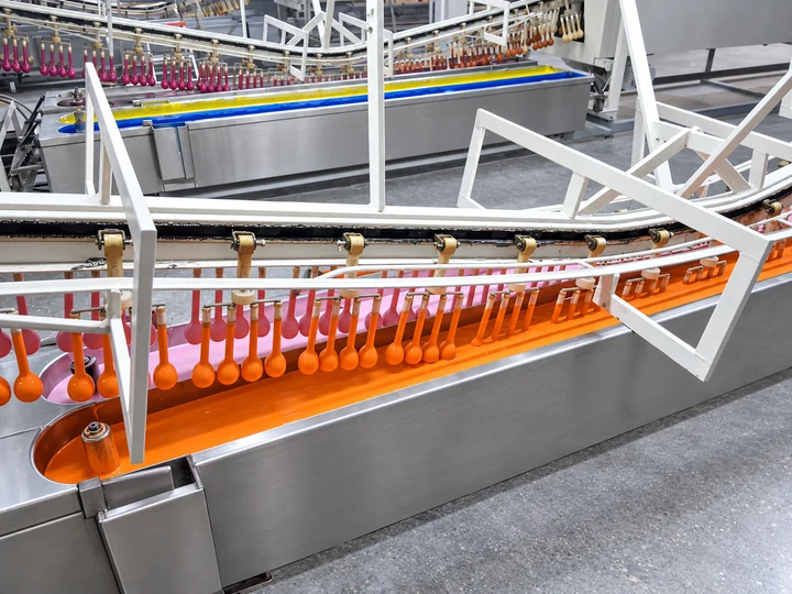 Línea de fabricación de globos, con transportadores de moldes y tanques de proceso.