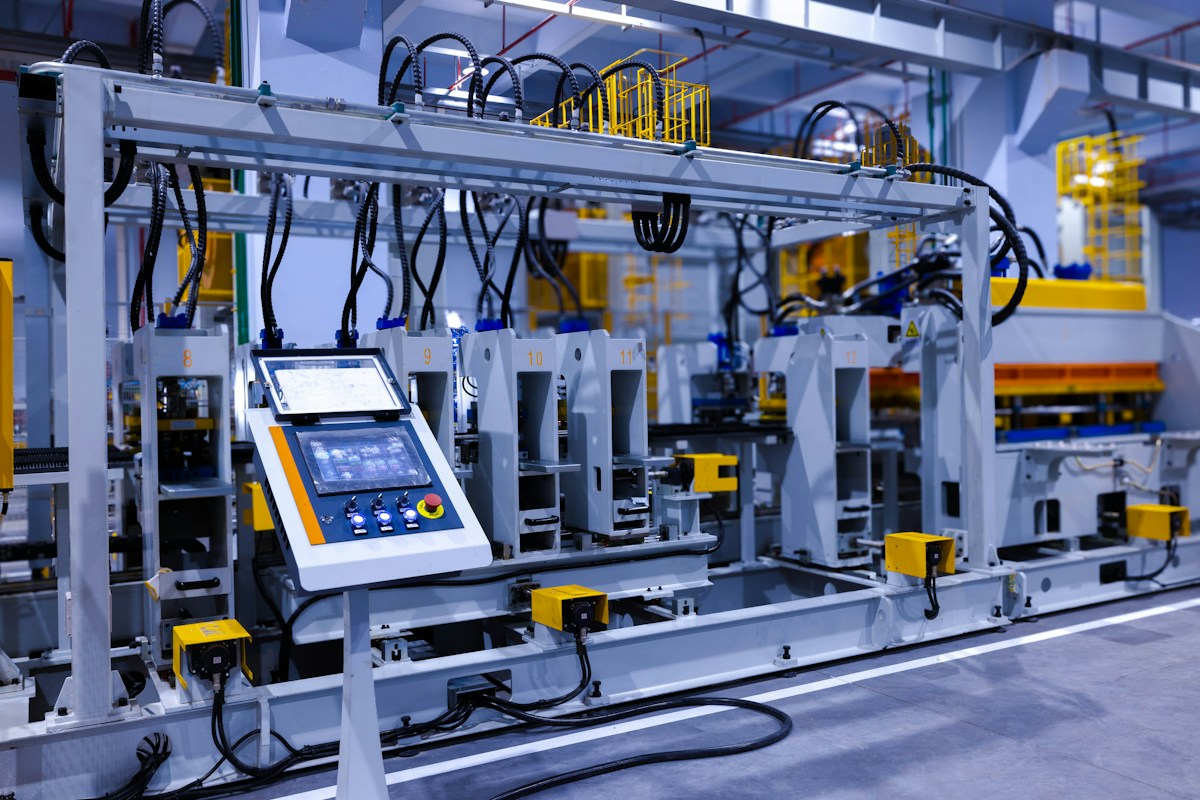 Línea industrial automatizada con panel de control y equipos de fabricación.