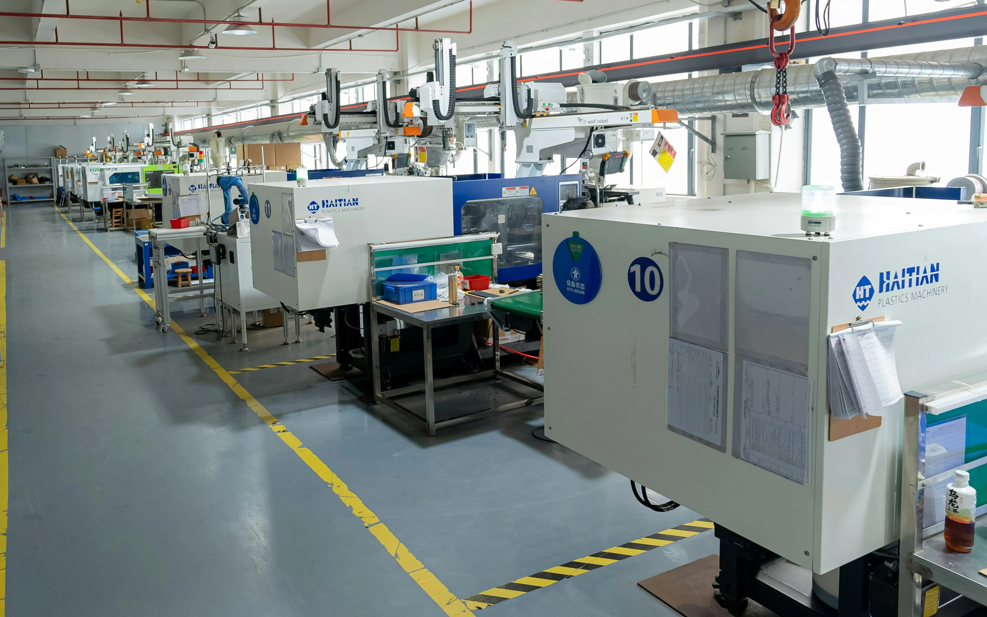 Illustrative view of Cartesian robots installed over plastic injection molding machines