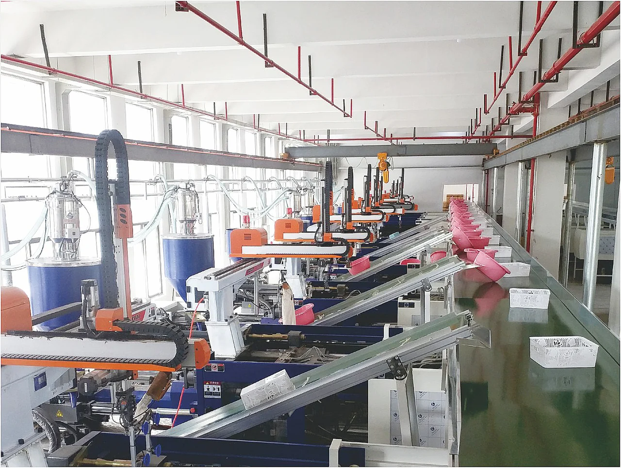 Cartesian robots installed on a line of injection molding machines, with inclined conveyors for the output of plastic parts