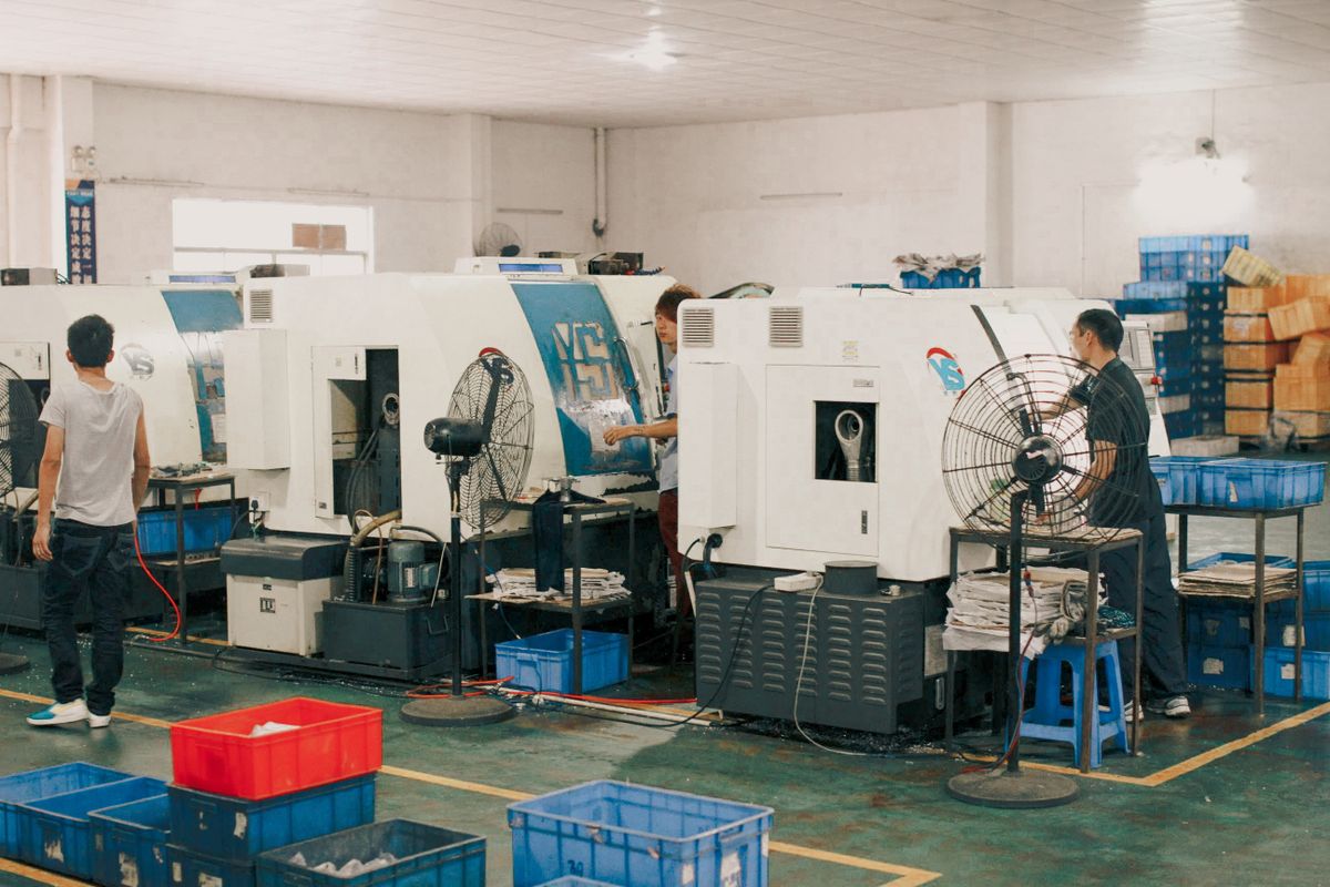 Equipo trabajando junto a máquinas en una unidad de producción industrial