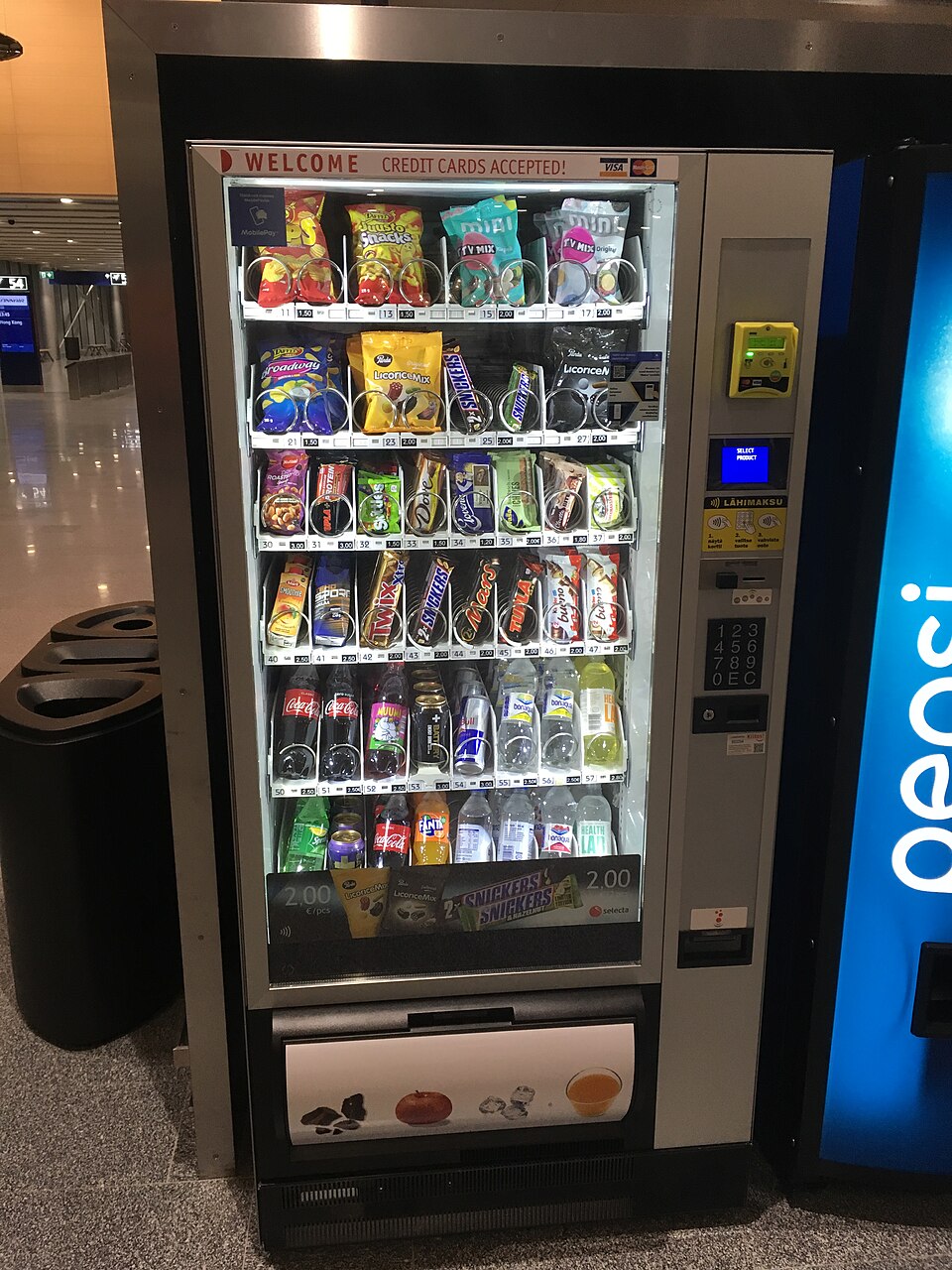 Exemplo real de vending machine com produtos embalados e bebidas em Helsinque